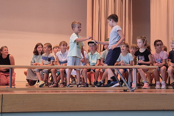 Mit Freude begrüssen die neuen ZweitklässlerInnen die neuen ErstklässlerInnen.